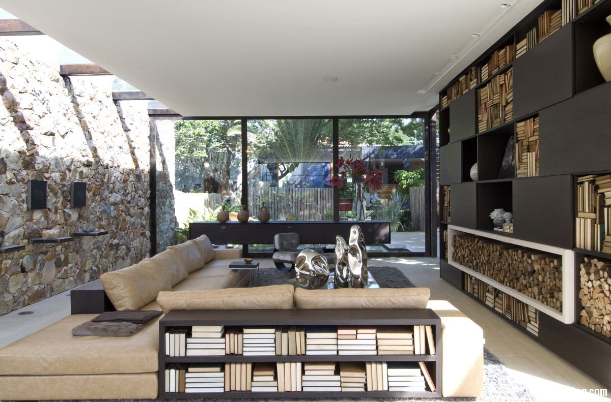 living area with view of yard and stone wall Biệt thự không có sự phân chia không gian nội thất và ngoại thất